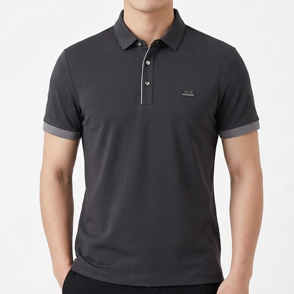 "A|X Armani Exchange men's black short-sleeve polo shirt with contrast grey tipping on collar and cuffs, AX logo chest patch and metallic placket buttons, displayed on hanger in Armani Exchange boutique"