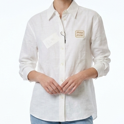 Person wearing a white shirt with a logo and light blue jeans on a white background