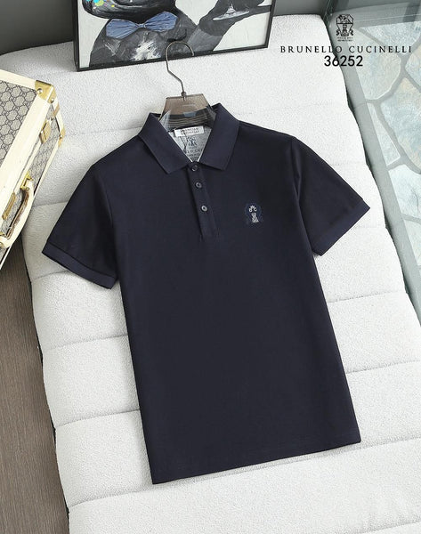 Navy blue  polo shirt on a white cushion with Brunello Cucinelli branding.
