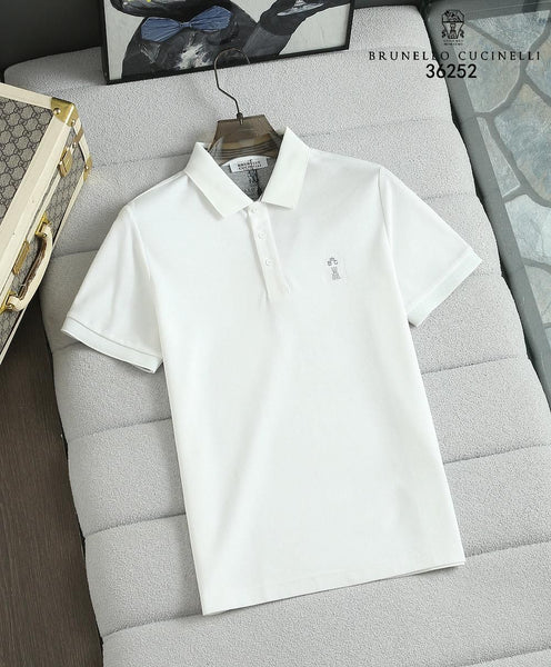 White polo shirt on a gray cushion with Brunello Cucinelli branding.